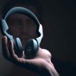 Технологии - Person holding noise cancelling headph