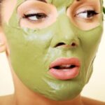 Красота и стиль - Woman applying clay mask on her face